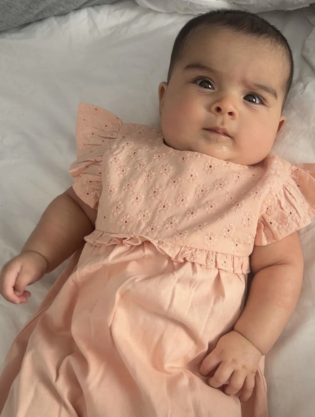 Yusra in a pink dress, looking towards the camera